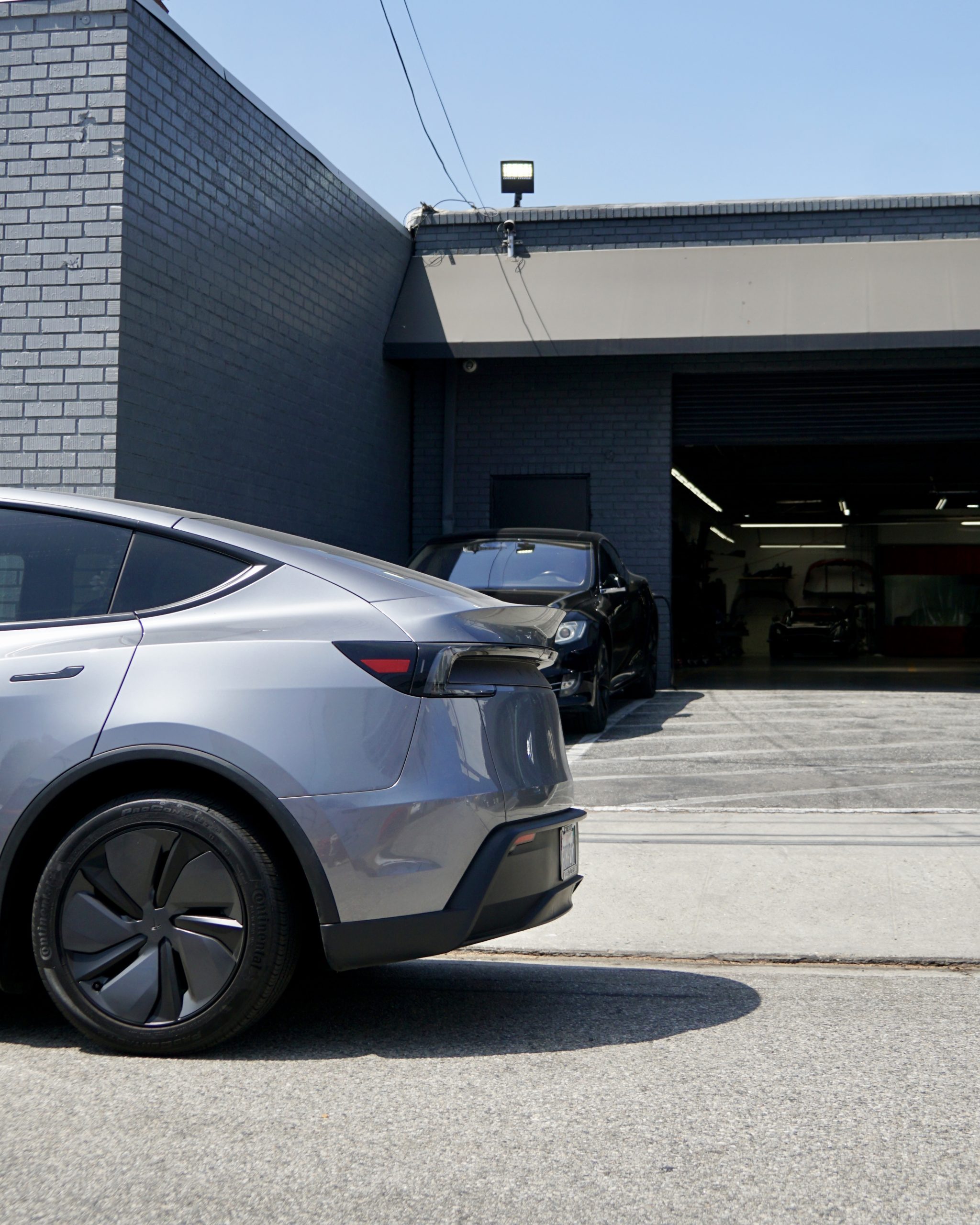 White Tesla Model 3 masked and prepped for sideswipe paint repair in a Los Angeles paint booth